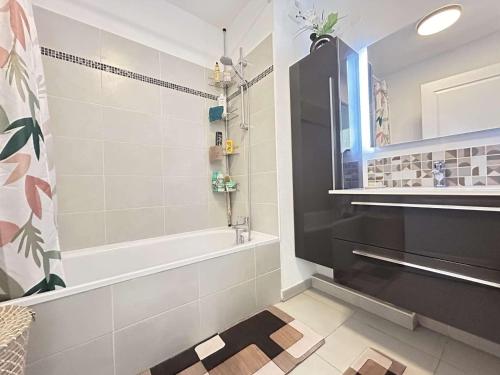 une salle de bain avec une baignoire et un lavabo dans l'établissement Mazet 3 pièces avec jardin, climatisation et parking au Muy - FR-1-226-554, au Muy