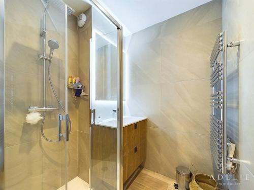 une salle de bain avec une douche avec une porte vitrée dans l'établissement Appartement T4 dernier étage avec cheminée et parking proche pistes - FR-1-398-678, à Montvalezan