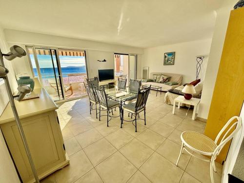 un salon avec une table en verre et des chaises dans l'établissement Appartement lumineux avec terrasse et accès plage - FR-1-816-15, au Lavandou