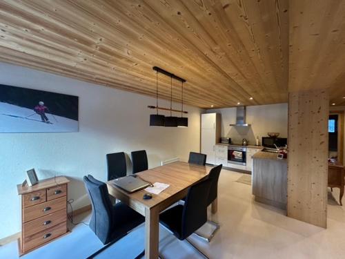 une salle à manger avec une table et des chaises en bois dans l'établissement Appartement spacieux avec balcon sud et parking couvert - FR-1-692-110, à La Chapelle-dʼAbondance