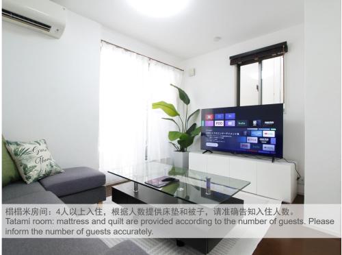 a living room with a glass table and a tv at New Open東新宿 戸建 in Tokyo