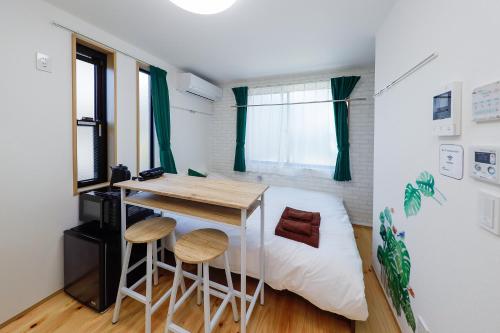 a small room with a desk and a bed at Zenith Shinjuku Hinoki by Tranova in Tokyo