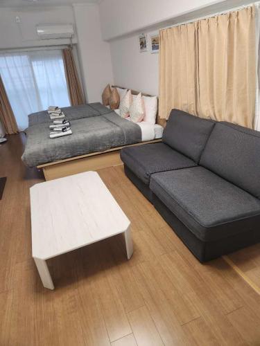 a living room with a couch and a coffee table at JR Shin-Osaka 2mins, Direct to Kansai Airport 關西空港直達,Shinkansen to Tokyo, Tokyo & Nagoya, Universal Studio 16 mins, Umeda 6 mins, Kyoto 25 mins, Early Check-In in Osaka