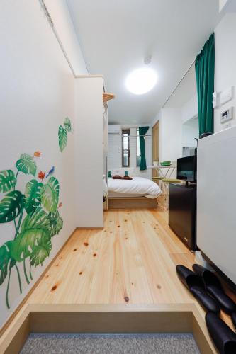 a bedroom with a bed in a room with wooden floors at Zenith Shinjuku Hinoki by Tranova in Tokyo