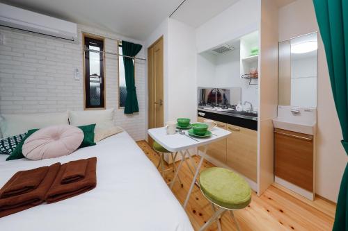 a bedroom with a white bed and a small table at Zenith Shinjuku Hinoki by Tranova in Tokyo