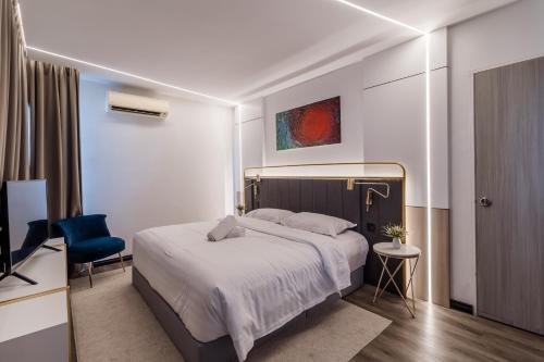 a bedroom with a bed and a blue chair at Regatta at Kozi Square Kuching in Kuching