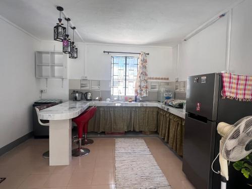a kitchen with a refrigerator and a table in it at Hebergement beau bassin in Beau Bassin