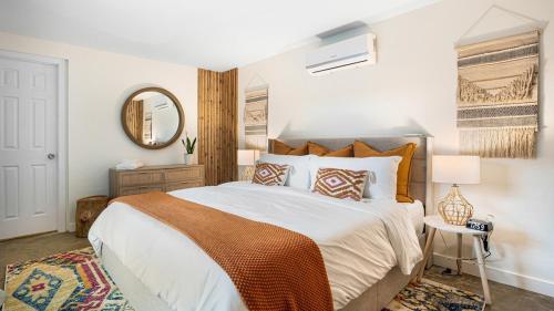 a bedroom with a large bed and a mirror at Luxury Tropical Oasis-4 BedRm Private Pool Retreat in Fort Myers