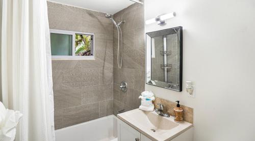a bathroom with a tub and a sink and a shower at Luxury Tropical Oasis-4 BedRm Private Pool Retreat in Fort Myers