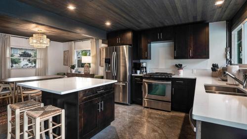 a kitchen with stainless steel appliances and wooden cabinets at Luxury Tropical Oasis-4 BedRm Private Pool Retreat in Fort Myers
