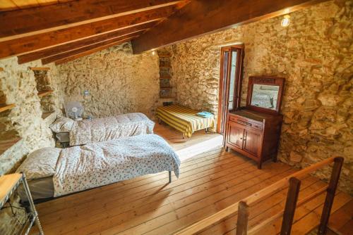 ein Zimmer mit zwei Betten und Holzboden in der Unterkunft Stonehouse apartments in Forcella