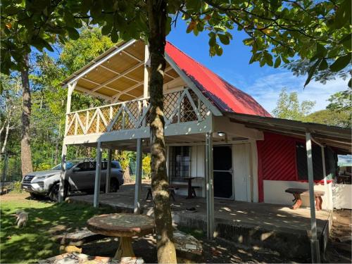 a house with a red roof and a car parked at Las Casitas de Playa Pochote. in Pochote