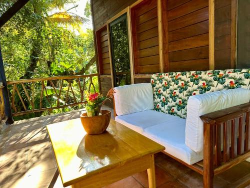 a couch sitting on a porch with a coffee table at Azure Del Mar in Maya Beach