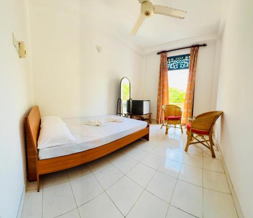 a bedroom with a bed and a desk and chair at Relax Home in Sri Jayewardenepura Kotte