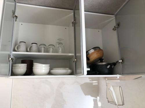 a white cabinet with dishes and other items in it at くわみずの森 in Kumamoto