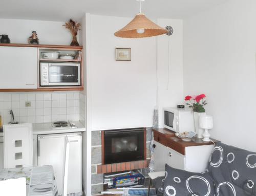 Il comprend une petite cuisine équipée d'un four micro-ondes et d'une télévision. dans l'établissement Appartement charmant à Villers-sur-Mer, 30 m², avec terrasse, à Villers-sur-Mer