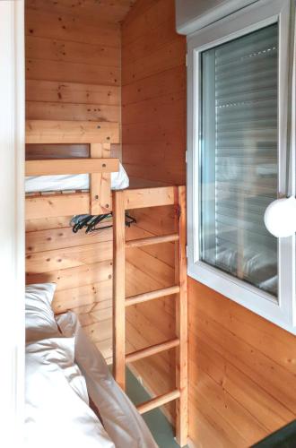 une chambre avec un lit superposé et une fenêtre dans l'établissement Chalet charmant à Saint-Jean-du-Gard, à Saint-Jean-du-Gard