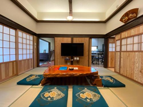 a living room with a table and a tv at 阿蘇のおばあちゃん家 in Aso