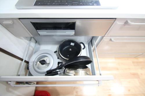 a kitchen cabinet with dishes and a microwave at 阿蘇のおばあちゃん家 in Aso