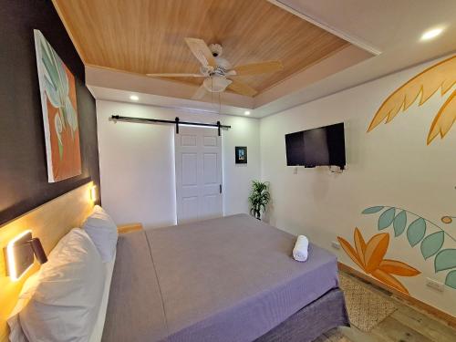 a room with a bed and a ceiling fan at Jungla Urbana, BnB in Pavas
