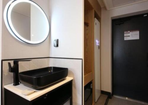 a bathroom with a black sink and a mirror at LABE Hotel in Jeonju