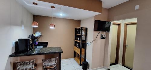 a kitchen with a counter top and a refrigerator at Flat no Village das Águas Resort ao lado do Parque Aquático Aldeia das Águas in Barra do Piraí