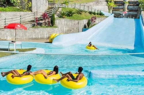 a group of women laying on rafts in a swimming pool at Flat no Village das Águas Resort ao lado do Parque Aquático Aldeia das Águas in Barra do Piraí