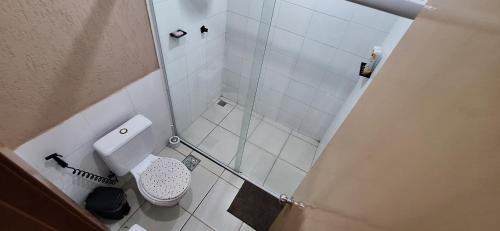 a small bathroom with a toilet and a shower at Flat no Village das Águas Resort ao lado do Parque Aquático Aldeia das Águas in Barra do Piraí