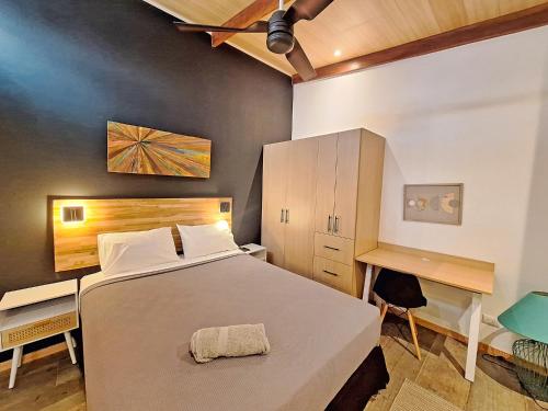 a bedroom with a large bed and a desk at Jungla Urbana, BnB in Pavas