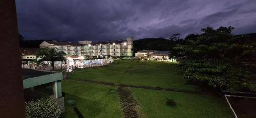 a large yard with a hotel at night at Flat no Village das Águas Resort ao lado do Parque Aquático Aldeia das Águas in Barra do Piraí