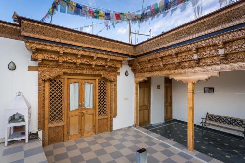 an old building with a wooden door and a checked floor at New Royal Guest House in Leh