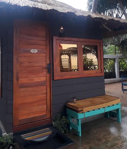 a small house with a bench and a window at Tomorrowland Beach Villas in Tangalle
