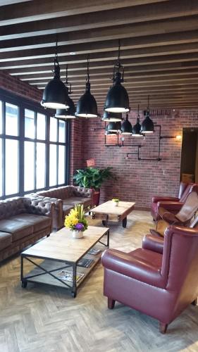 a living room with couches and a brick wall at City Suites - Kaohsiung Pier2 in Kaohsiung