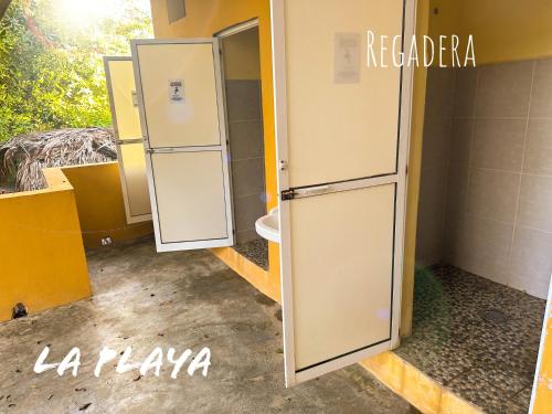 a bathroom with a white refrigerator in a room at Hotel La Playa in Mazunte