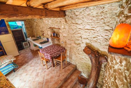 ein Zimmer mit einem Tisch und einer Küche in einem Haus in der Unterkunft Stonehouse apartments in Forcella