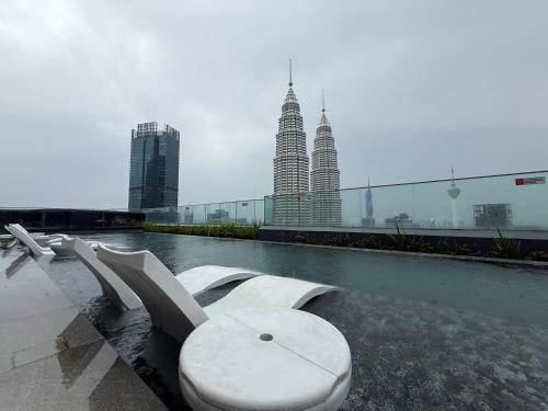 a pool of water with benches and some tall buildings at Star Residence KL in Kuala Lumpur