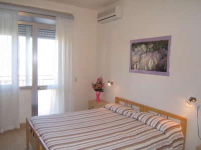 a bedroom with a bed in a room with a window at Hotel Tokio in Lido di Jesolo