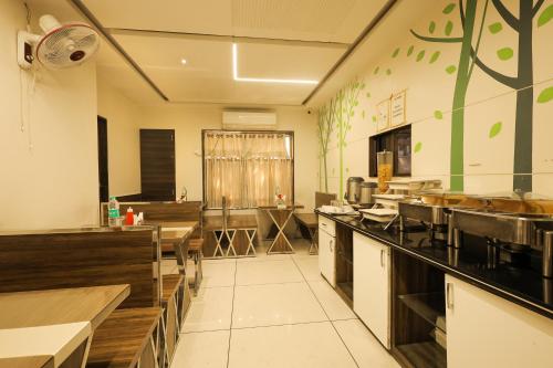 a large kitchen with tables and sinks in a restaurant at Hotel New Apex in Ankleshwar