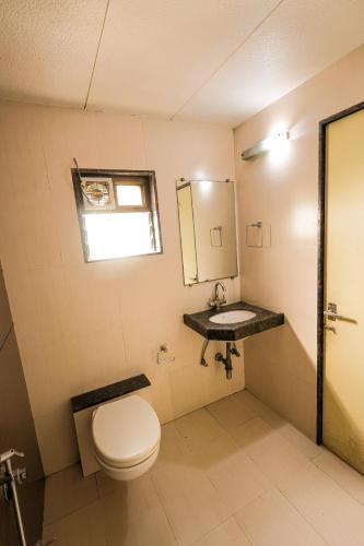 a bathroom with a toilet and a sink at Hotel New Apex in Ankleshwar