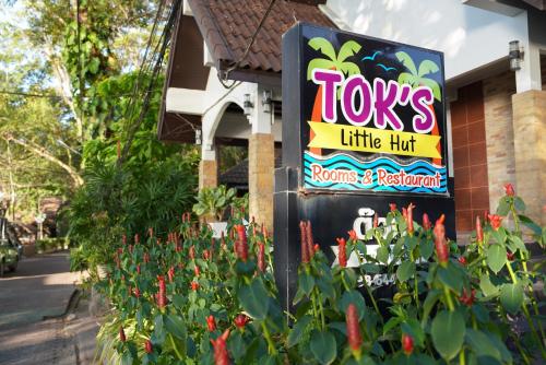 a sign for a tons little hot restaurant with red flowers at Tok Little Hut in Rayong