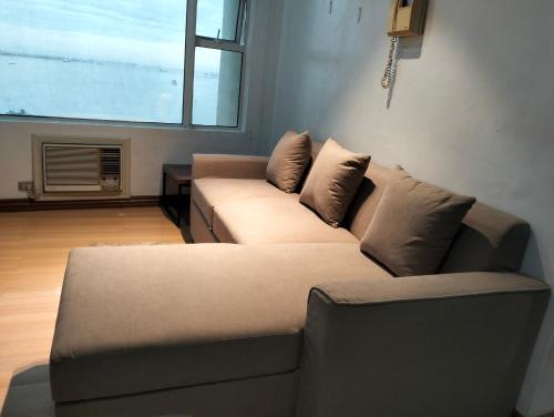 a living room with a couch and a window at Chic Haven in Manila