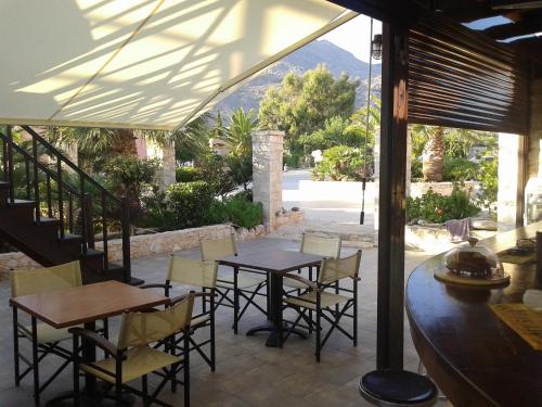 a patio with tables and chairs and a view of a mountain at Kallicrates Village in Frangokastello