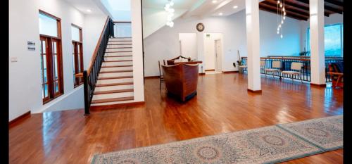 a living room with wooden floors and a staircase at Tea Hills Lake in Hatton