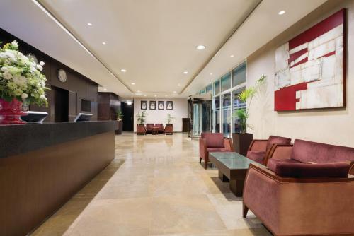 a lobby of a hospital with chairs and a reception desk at Ramada Downtown Abu Dhabi in Abu Dhabi