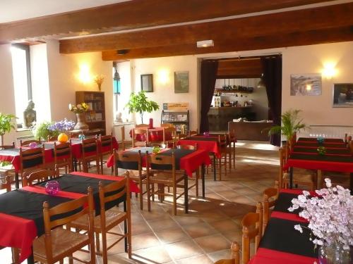 un restaurant avec des tables et des chaises rouges et noires dans l'établissement Gite d'Etape Ascou La Forge, à Ascou