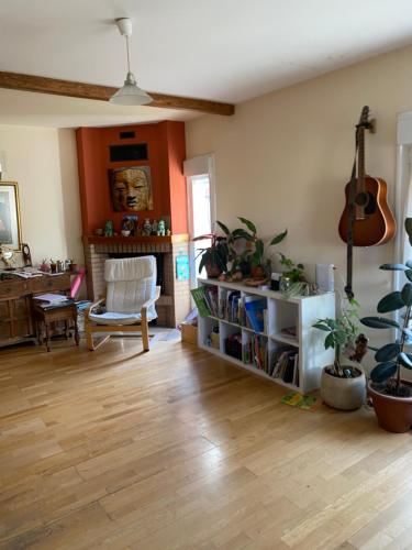 a living room with wooden floors and a guitar at La Casita Azul in Cáseda
