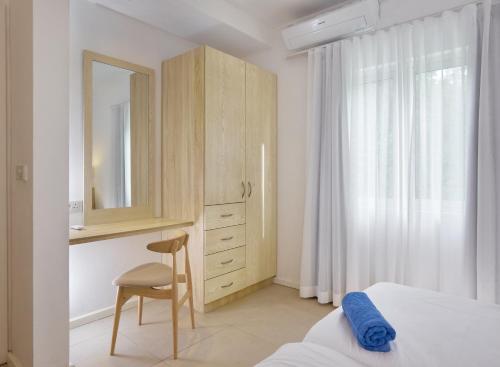 a bedroom with a bed and a dresser and a mirror at Le Beachclub in Pereybere