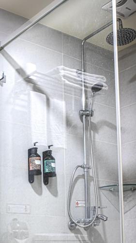 a shower in a bathroom with two soap bottles at West Hotel in Puli
