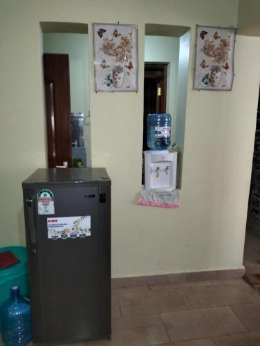 a room with a refrigerator and two pictures on the wall at Blooms 25 Apartments in Nairobi