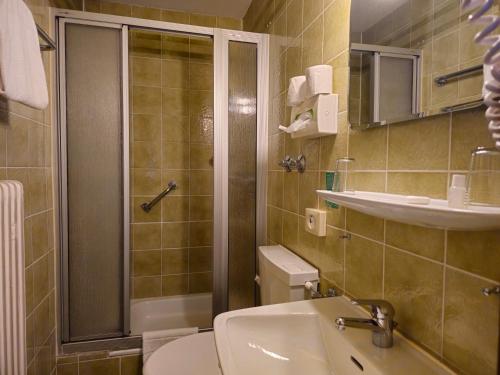 a bathroom with a shower and a toilet and a sink at ARRIVEL Hotel am Bergson - bisher Hotel Neuner in Munich